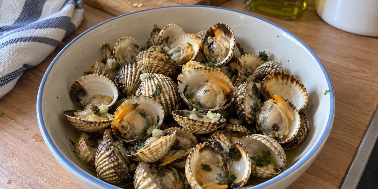 Coques ouvertes à la casserole, servies avec leur jus et du persil